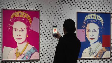Un hombre toma una foto de una impresión en serigrafía que muestra a la Reina Isabel II, parte de la serie de dieciséis impresiones de cuatro reinas, titulada Reigning Queens, 1985, de Andy Warhol, en el museo Paleis Het Loo en Apeldoorn, Holanda, el miércoles 9 de octubre de 2024, similares a las obras del artista robadas de una galería de Oisterwijk, Holanda, en las primeras horas del viernes 1 de noviembre de 2024. (AP Foto/Peter Dejong)
