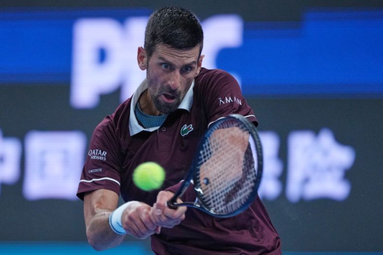 El serbio Novak Djokovic hace una devolución al australiano Alex de Miñaur en la final del Abierto de China en Beijing, el martes 6 de octubre de 2026 (AP Foto/Achmad Ibrahim)
