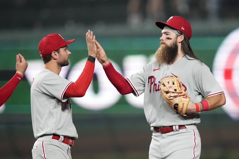 El campocorto Trea Turner y el jardinero Brandon Marsh de los Filis de Filadelfia celebran el triunfo de su equipo ante los Cachorros de Chicago el martes 27 de junio del 2023. (AP Foto/Charles Rex Arbogast)