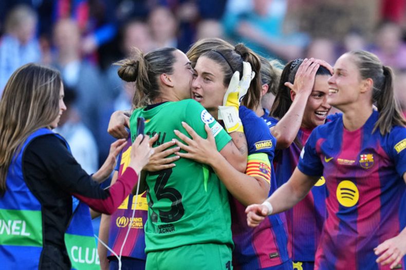 La portera del Barcelona Catalina Coll le da un beso a la capitana del equipo Alexia Putellas durante la celebración tras ganar la Liga de Campeones al vencer al Lyon en Oslo el sábado 23 de mayo del 2026. (AP Foto/Kirsty Wigglesworth)