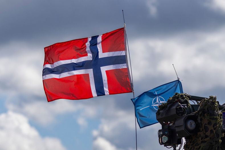 ARCHIVO - Las banderas de Noruega (izquierda) y la OTAN, vistas durante las maniobras militares Iron Wolf 2025-I en la zona de entrenamiento de Gaiziunai, Lituania, el 16 de mayo de 2025. (AP Foto/Mindaugas Kulbis, archivo)