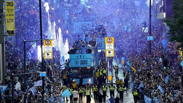 Jugadores del Manchester City recorren las calles de la ciudad en autobús descapotable para festejar con la afición tras ganar la tripleta de títulos el lunes 12 de junio del 2023. (Danny Lawson/PA via AP)