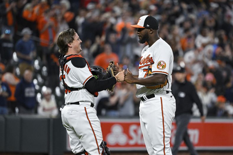 Adley Rutschman, cátcher de los Orioles de Baltimore, felicita al dominicano Félix Bautista, tras el duelo ante los Angelinos de Los Ángeles, el miércoles 17 de mayo de 2023 (AP Foto/Terrance Williams)