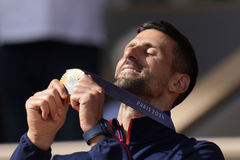 El serbio Novak Djokovic admira su medalla de oro tras vencer al español Carlos Alcaraz en la final de sencillos masculino del tenis de los Juegos Olímpicos de París, el domingo 4 de agosto de 2024. (AP Foto/Manu Fernández)
