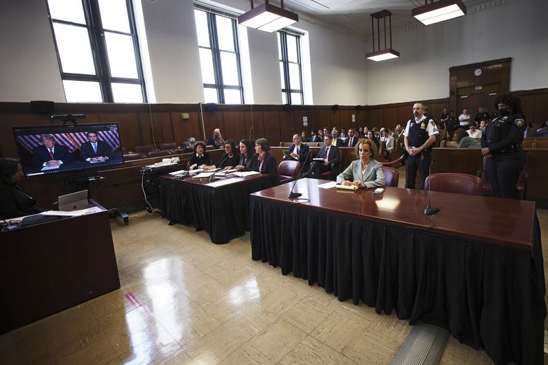 El expresidente Donald Trump (a la izquierda en la pantalla) y su abogado Todd Blanche (a la derecha en la pantalla) compareciendo por video mientras otra abogada, Susan Necheles (derecha), observa, en un tribunal de Nueva York el 23 de mayo de 2023. (Foto AP /Curtis Means vía Pool)
