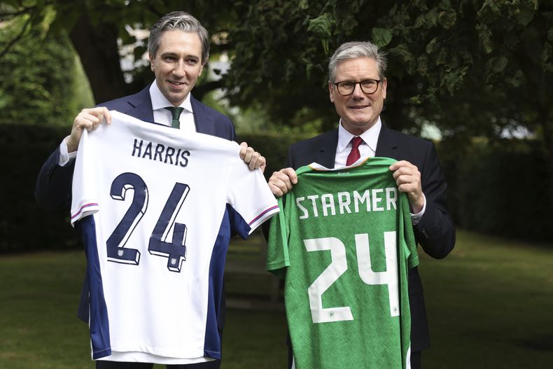 El primer ministro de Irlanda, Simon Harris, izquierda, y su homólogo británico, Keir Starmer, sostienen las camisetas de los equipos de fútbol de sus países, cada una con el nombre del otro, en Farmleigh House, en Dublín, Irlanda, el sábado 7 de septiembre de 2024. (AP Foto/Peter Morrison Pool)