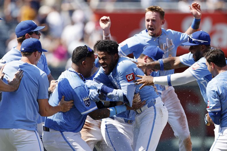 El venezolano Maikel Garcia de los Reales de Kansas City celebra con su compatriota Salvador Pérez y otros compañeros tras pegar un doble de dos carreras frente a los Yankees de Nueva York el jueves 13 de junio del 2024. (AP Foto/Colin E. Braley)