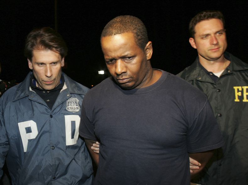 ARCHIVO - En esta foto del jueves 21 de mayo de 2009, James Cromitie, en el centro, es escoltado por agentes de policía desde un edificio federal en Nueva York tras ser detenido por cargos relacionados con un atentado con bomba en el Bronx. (AP Foto/Robert Mecea, Archivo)