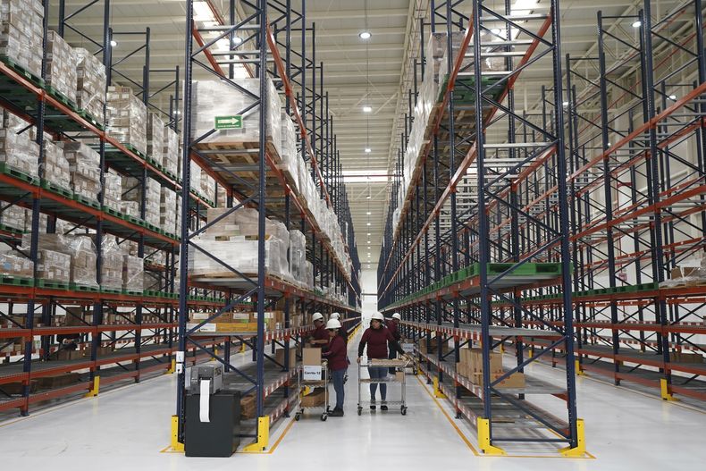 Los trabajadores desempacan medicamentos en un almacén de megafarmacia el día de su inauguración en Huehuetoca, México, el viernes 29 de diciembre de 2023. (AP Foto/Fernando Llano)