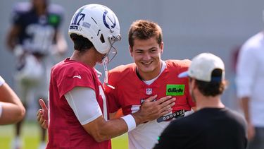 El quarterback de los Patriots de Nueva Inglaterra, Drake Maye (derecha), saluda al quarterback de los Colts de Indianápolis, Daniel Jones (17), antes de una sesión de práctica conjunta en un campamento de entrenamiento de fútbol americano de la NFL en Foxborough, Massachusetts, el martes 11 de agosto de 2026. (Foto AP/Charles Krupa)