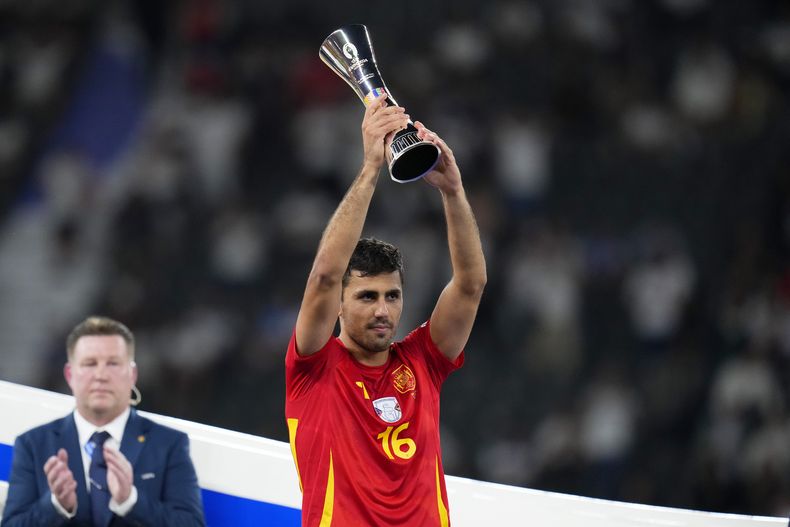 El español Rodri alza el troFeo del Mejor Jugador del torneo después de la final entre España e Inglaterra en la Euro 2024, en Berlín, Alemania, el domingo 14 de julio de 2024. España ganó 2-1. (AP Foto/Manu Fernandez)