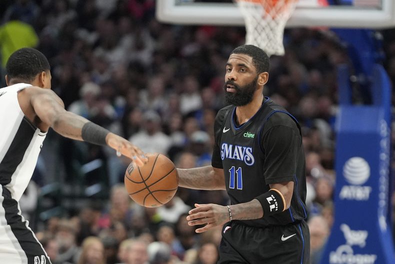 Kyrie Irving, base de los Mavericks de Dallas, dribla a Blake Wesley, de los Spurs de San Antonio, en el encuentro del miércoles 14 de febrero de 2024 (AP Foto/LM Otero)