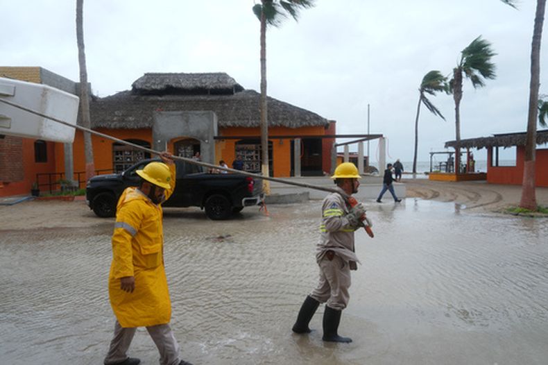 Trabajadores remolcan una embarcación a tierra mientras el huracán Polo se aproxima a Puerto San Carlos en el estado de Baja California, en México, el lunes 28 de septiembre de 2026. (AP Foto/Eduardo Verdugo)