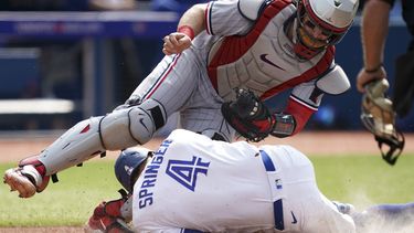 George Springer, de los Azulejos de Toronto, choca con el cátcher Ryan Jeffers, de los Mellizos de Minnesota, en el juego del sábado 10 de junio de 2023 (Arlyn McAdorey/The Canadian Press via AP)