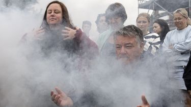 Gente reunida para una ceremonia tradicional aborigen de humo durante la Ceremonia de Reflexión de Duelo We-Akon Dilinja en el Día de Australia, en Melbourne, el domingo 26 de enero de 2025. (Diego Fedele/AAP Image via AP)