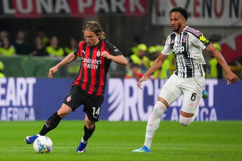 Luka Modric (izquierda) del AC Milan avanza con el balón ante Lloyd Kelly de Juventus en la Serie A, el domingo 26 de abril de 2026, en Milán. (Alessio Morgese/LaPresse vía AP)