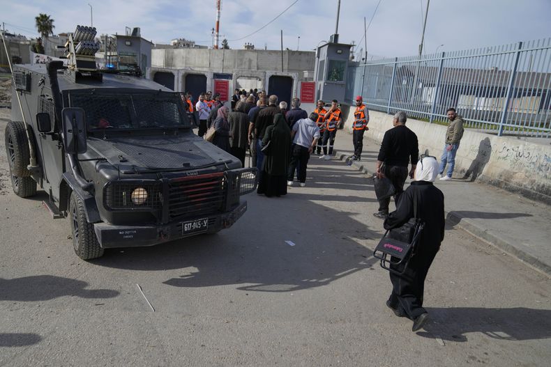 Un grupo de palestinos cruza desde el retén del Ejército israelí en Kalandia, cerca de la ciudad cisjordana de Ramala, hacia Jerusalén, para participar en las oraciones del viernes en la mezquita de Al-Aqsa, durante el mes sagrado musulmán de ramadán, el viernes 14 de marzo de 2025. (AP Foto/Nasser Nasser)