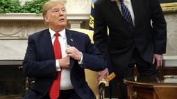 ARCHIVO - El jefe de despacho de la Casa Blanca, John Kelly (derecha), se agacha para hablar con el presidente estadounidense Donald Trump en la Oficina Oval de la Casa Blanca, en Washington, el 27 de junio de 2018. (AP Foto/Pablo Martinez Monsivais, Archivo)