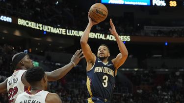 CJ McCollum (3), de los Pelicans de Nueva Orleans, se alista para anotar sobre Jimmy Butler (22) y Haywood Highsmith (24), del Heat de Miami, durante la primera mitad del juego de baloncesto de la NBA, el viernes 22 de marzo de 2024, en Miami. (AP Foto/Marta Lavandier)