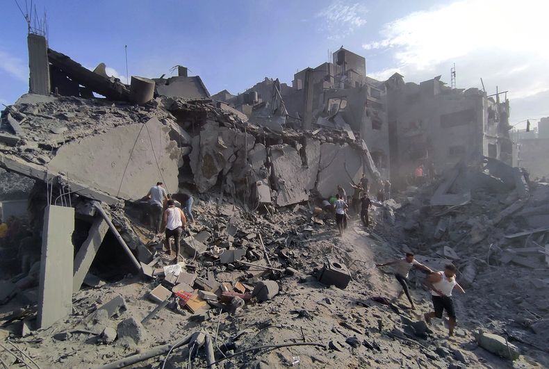 Palestinos inspeccionan los daños en los edificios destruidos por ataques aéreos israelíes contra el campo de refugiados de Jabaliya, a las afueras de la Ciudad de Gaza, el 31 de octubre de 2023 (AP Foto/Abdul Qader Sabbah)