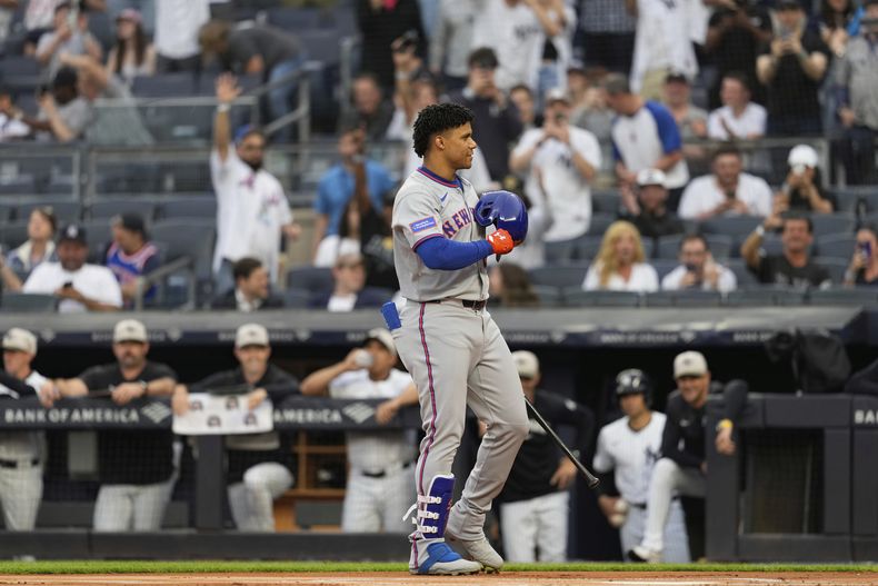 Juan Soto, de los Mets de Nueva York, reconoce la reacción de los fanáticos de los Yankees, colocando su casco en el corazón, mientras se dirige rumbo al plato para su turno al bate durante la primera entrada del juego de béisbol de Grandes Ligas en la denominada Serie del Metro, el viernes 16 de mayo de 2025, en Nueva York. (AP Foto/Seth Wenig)