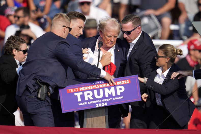 ARCHIVO – El candidato presidencial republicano y expresidente Donald Trump recibe ayuda para abandonar el escenario en un evento de campaña en Butler, Pensilvania, el 13 de julio de 2024. (AP Foto/Gene J. Puskar, Archivo)