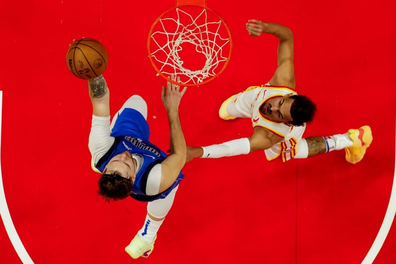 El esloveno Luka Doncic, de los Mavericks de Dallas, encesta frente a Trae Young, de los Hawks de Atlanta, en el partido del viernes 26 de enero de 2024 (AP Foto/Mike Stewart)