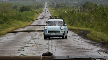 La gente conduce por una carretera llena de cables eléctricos caídos tras el paso del huracán Rafael en San Antonio de los Baños, Cuba, el jueves 7 de noviembre de 2024. (Foto AP/Ramón Espinosa)