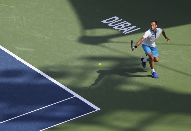 El rumano Marius Copil devuelve una pelota ante el checo Tomas Berdych en el torneo de Dubai el martes, 25 de febrero de 2014, en Dubai. (AP Photo/Kamran Jebreili)