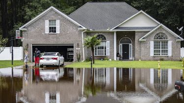 Keon Johnson y su esposa, Zyla Johnson, a la izquierda, hablan sobre cómo llegar a trabajar dado que su casa se ha inundado por las lluvias de la tormenta tropical Debby, el miércoles 7 de agosto de 2024 en Pooler, Georgia. (AP Foto/Stephen B. Morton)