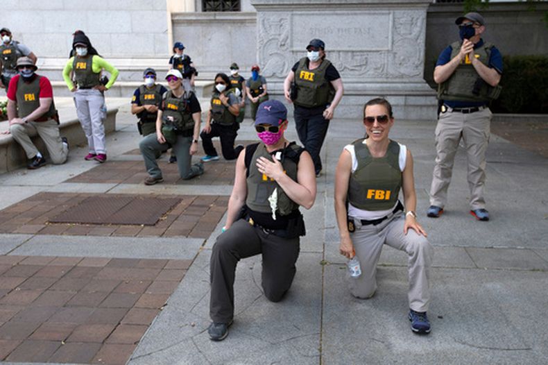 Agentes del FBI se arrodillan junto con manifestantes en medio de protestas por la muerte de George Floyd en Washington el 4 de junio del 2020. (AP foto/Jose Luis Magana)