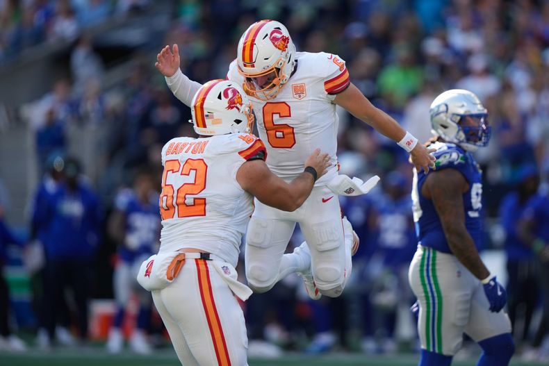 El quarterback de los Buccaneers de Tampa Bay, Baker Mayfield, celebra con el centro Graham Barton (62) después de una conversión de dos puntos en la segunda mitad del partido ante los Seahawks de Seattle, el domingo 5 de octubre de 2025, en Seattle. (AP Foto/Stephen Brashear)
