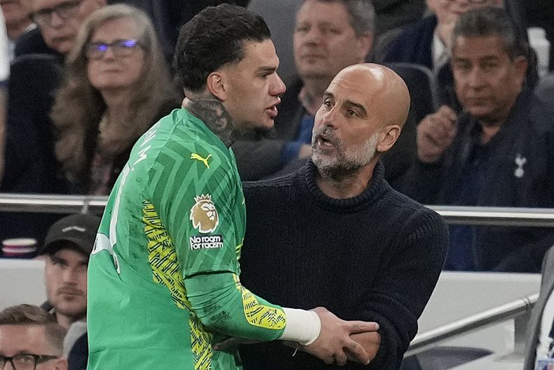 El arquero del Manchester City Ederson conversa con el técnico Pep Guardiola al salir del partido contra Tottenham en la Liga Premier, el martes 14 de mayo de 2024.(AP Foto/Kin Cheung)