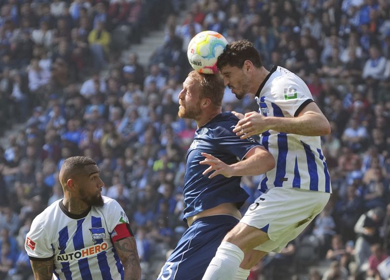 Philipp Hofmann del Bochum y Agustin Maximiliano Rogel del Hertha Berlín saltan por el balón en el encuentro de la Bundesliga en el Estadio Olímpico el sábado 20 de mayo del 2023. (Soeren Stache/dpa via AP)