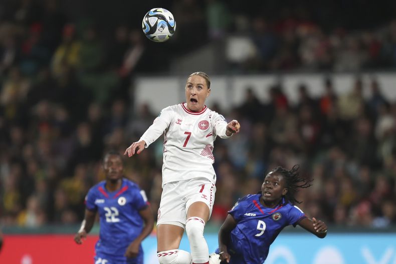 La danesa Sanne Troelsgaard cabecea al balón frente a la haitiana Sherly Jeudy (derecha) en el partido del Mundial femenino, el martes 1 de agosto de 2023, en Perth, Australia. (AP Foto/Gary Day)