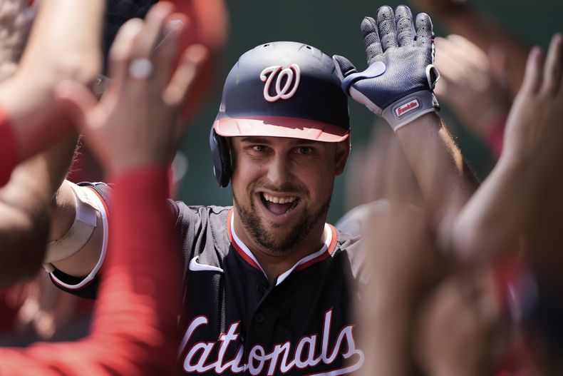 Nathaniel Lowe, de los Nacionales de Washington, celebra en el dugout después de batear un grand slam durante la primera entrada del juego de béisbol de Grandes Ligas en contra de los Reales de Kansas City, el miércoles 13 de agosto de 2025, en Kansas City, Missouri. (AP Foto/Charlie Riedel)