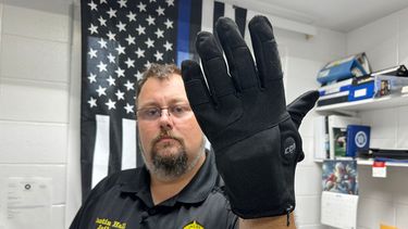 Justin Hall, un guardia penitenciario en el condado Nelson, muestra un guante de electrochoques en Bardstown, Kentucky, el 13 de agosto del 2026. (AP foto/Dylan Lovan)