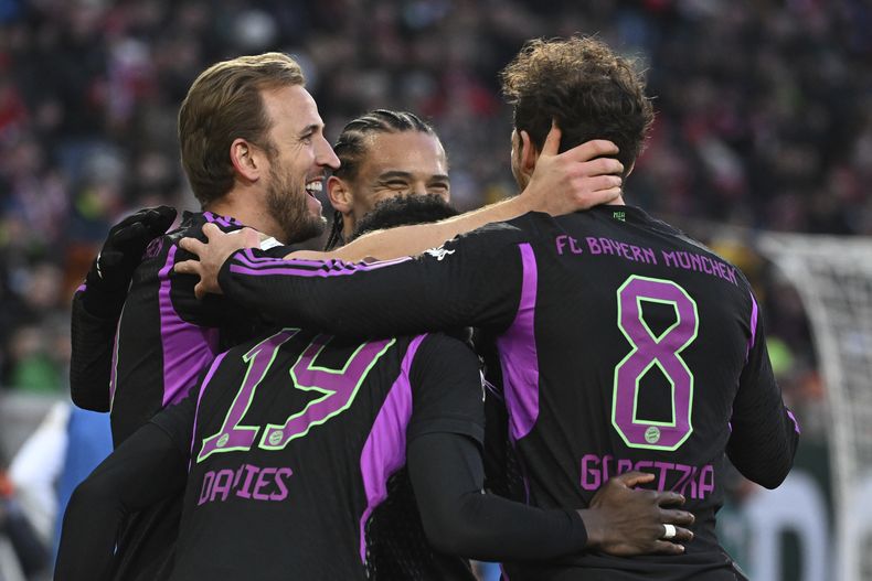 Harry Kane (izquierda) del Bayern Múnich celebra con sus compañeros tras marcar un gol ante Augsburgo en la Bundesliga, el sábado 27 de enero de 2024. (Sven Hoppe/dpa vía AP)
