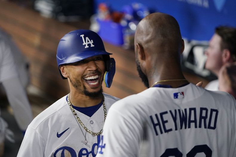 Mookie Betts, de los Dodgers de Los Ángeles, festeja con Jason Heyward luego de conectar un jonrón en el juego dle martes 29 de agosto de 2023, ante los Diamondbacks de Arizona (AP Foto/Ryan Sun)