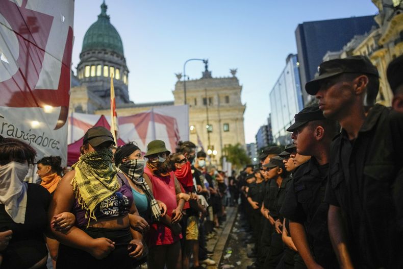 Manifestantes contra el gobierno forman una cadena humana frente a un cordón policial que custodia el Congreso donde los legisladores debaten una reforma impulsada por el presidente argentino, Javier Milei, en Buenos Aires, Argentina, el jueves 1 de febrero de 2024. La propuesta incluye una amplia variedad de medidas económicas, administrativas, penales y medioambientales. (AP Foto/Natacha Pisarenko)