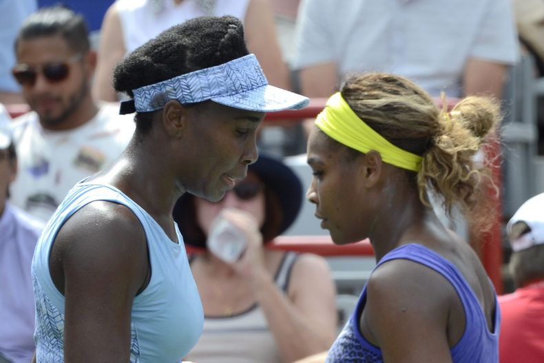 Venus Williams (izquierda) y su hermana Serena caminan hacia sus respectivas sillas durante una pausa en su partido semifinal en el torneo de Montreal, el s&aacute;bado 9 de agosto de 2014 (AP Foto/The Canadian Press, Paul Chiasson)