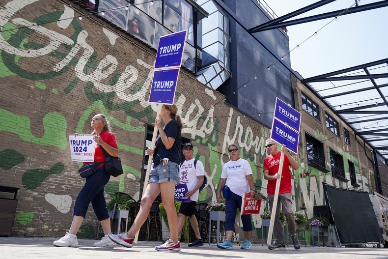 Simpatizantes del expresidente Donald Trump caminan cerca del Fiserv Forum, donde se llevará a cabo el primer debate republicano de estas primarias, el martes 22 de agosto de 2023, en Milwaukee. (AP Foto/Morry Gash)