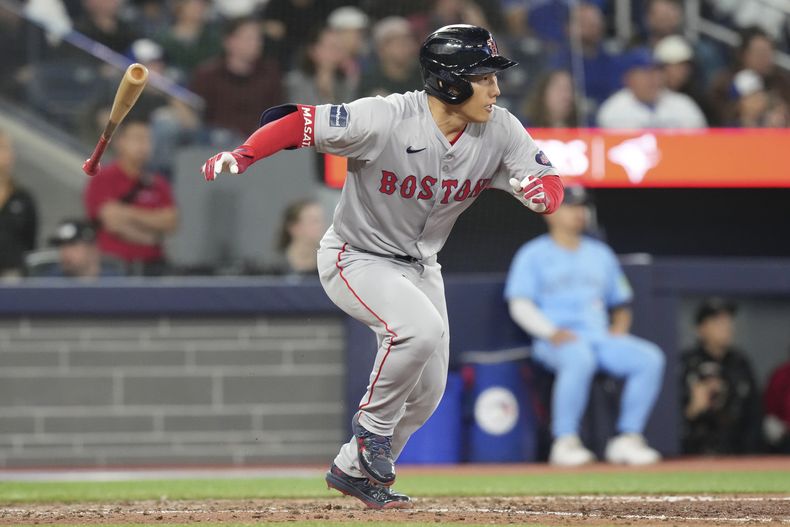 Masataka Yoshida, de los Medias Rojas de Boston, batea para una jugada de selección y anota una carrera durante la octava entrada del partido de béisbol contra los Azulejos en Toronto, el martes 24 de septiembre de 2024. (Chris Young/The Canadian Press vía AP)