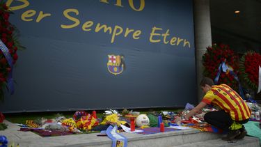americateve | Un hombre coloca flores para rendir homenaje al fenecido ex t&eacute;cnico del Barcelona, Tito Vilanova, el viernes, 25 de abril de 2014, frente al estadio Camp Nou de Barcelona. (AP Photo/Manu Fernandez)