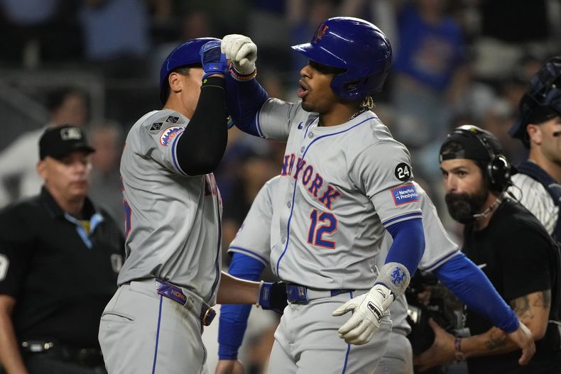 Francisco Lindor, derecha, de los Mets de Nueva York, celebra con José Iglesias después de conectar jonrón de tres carreras en el que anotaron Iglesias y Tyrone Taylor durante la octava entrada del juego de béisbol en contra de los Yankees de Nueva York, el miércoles 24 de julio de 2024, en Nueva York. (AP Foto/Pamela Smith)