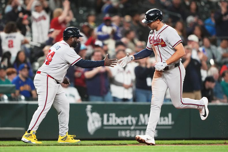 Matt Olson, de los Bravos de Atlanta, saluda al coach de tercera base Tommy Watkins mientras trota hacia el plato después de conectar un jonrón solitario contra los Marineros de Seattle durante la novena entrada de un partido de béisbol, el martes 5 de mayo de 2026, en Seattle. (Foto AP/Lindsey Wasson)