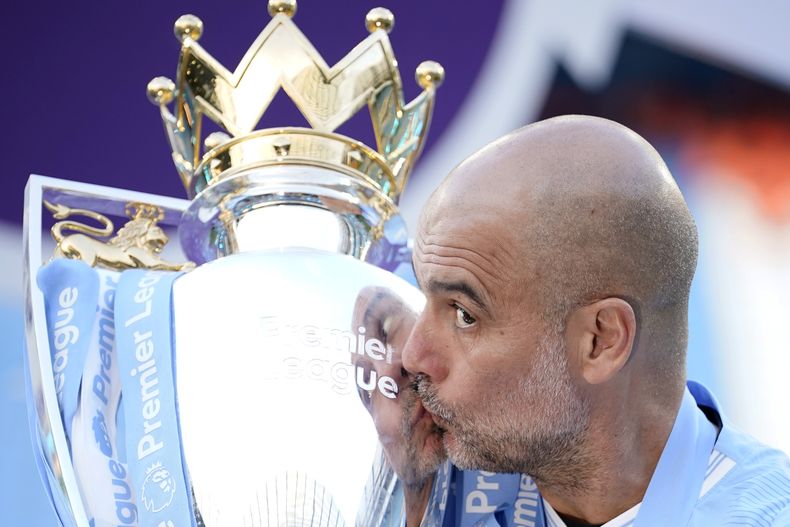 ARCHIVO - El técnico del Manchester City Pep Guardiola besa el trofeo de campeón de la Liga Premier, el domingo 19 de mayo de 2024. (AP Foto/Dave Thompson)