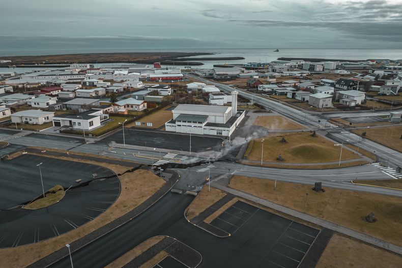 Esta imagen tomada con un dron muestra grietas en una calle al lado de una iglesia, en el pueblo pesquero de Grindavik, Islandia, el jueves 16 de noviembre de 2023. (AP Foto/Bjorn Steinbekk)