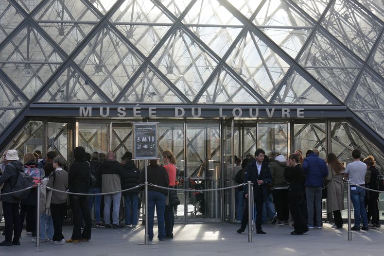 Visitantes en fila para entrar al museo del Louvre tres días después de que joyas históricas fueran robadas en un audaz robo a plena luz del día, el miércoles 22 de octubre de 2025 en París. (Foto AP/Thibault Camus)