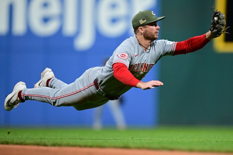 Matt McLain, de los Rojos de Cincinnati, se lanza para atrapar batazo de Travis Bazzana, de los Guardianes de Cleveland, durante la novena entrada del juego de béisbol de Grandes Ligas del viernes 15 de mayo de 2026, en Cleveland. (AP Foto/David Dermer)